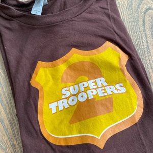 Brown Super Troopers 2 Tee. Machine wash safe. Official movie licensed.
